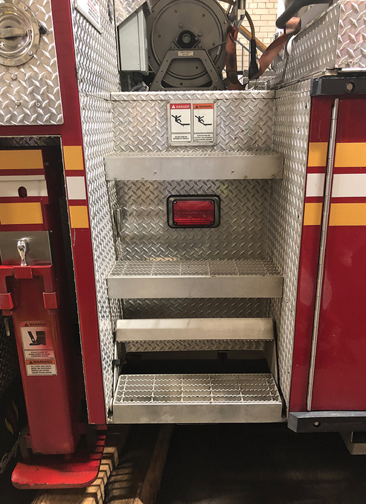 Access stairs leading up to an FDNY Seagrave tower ladder’s bucket are offered on both rear sides of the apparatus.