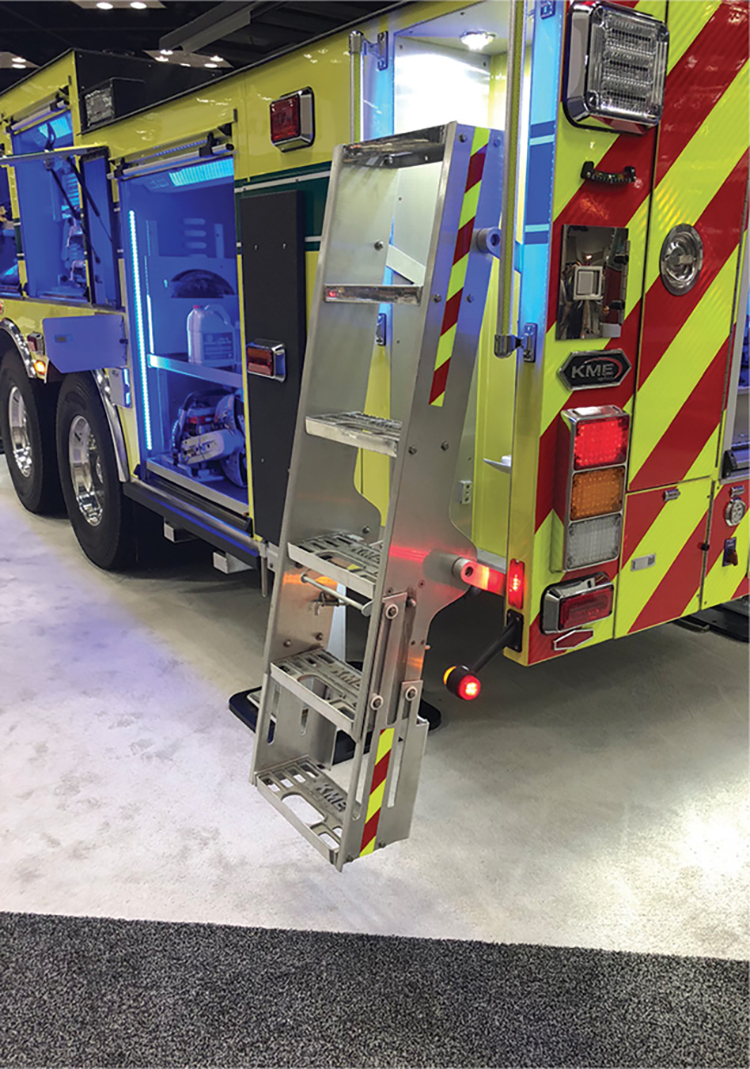 This KME apparatus has a hinged ladder that pivots out of its storage receptacle with a retractable bottom step. There is sufficient light near the ladder, and it has two hand rails for overall firefighter safety.