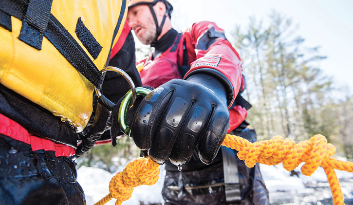 A rescuer has a Sterling Rope GrabLine water rescue rope tethered to his PFD prior to entering the water.  