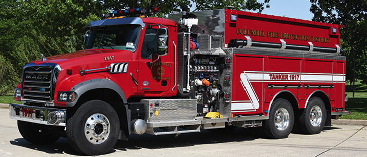 One of nine pieces operated by the Columbia (IL) Fire Protection District is this 3,000-gallon Rosenbauer pumper-tanker with a 1,500-gpm pump on a tandem Mack two-door chassis. It has an electric dump valve with a swiveling chute and a powered portable tank rack. Note the extra-long hard sleeve above the side compartments.