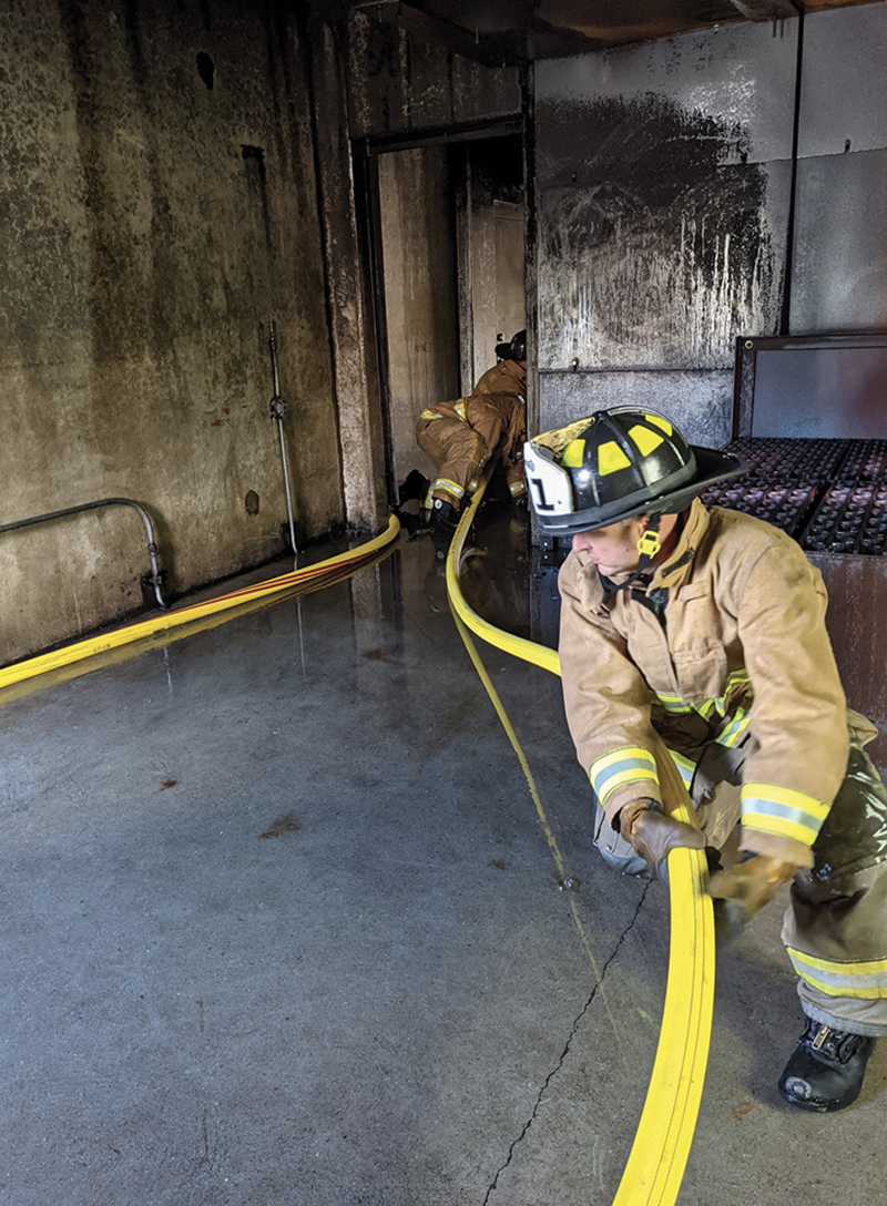 Firefighters advance Mercedes Textiles’ KRAKENEXO® Super II attack line in a training building.