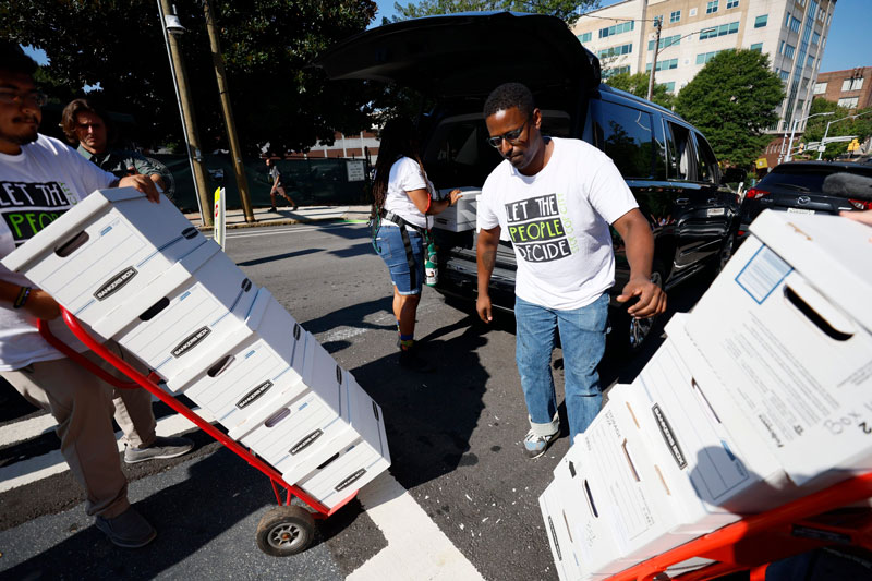 Forest defenders assisted in unloading sixteen boxes containing more than 100,000 signatures from a petition. They plan to submit this petition at City Hall on Monday, September 10, 2023, to have the matter of the training center included in the upcoming ballot. Miguel Martinez /miguel.martinezjimenez@ajc.com